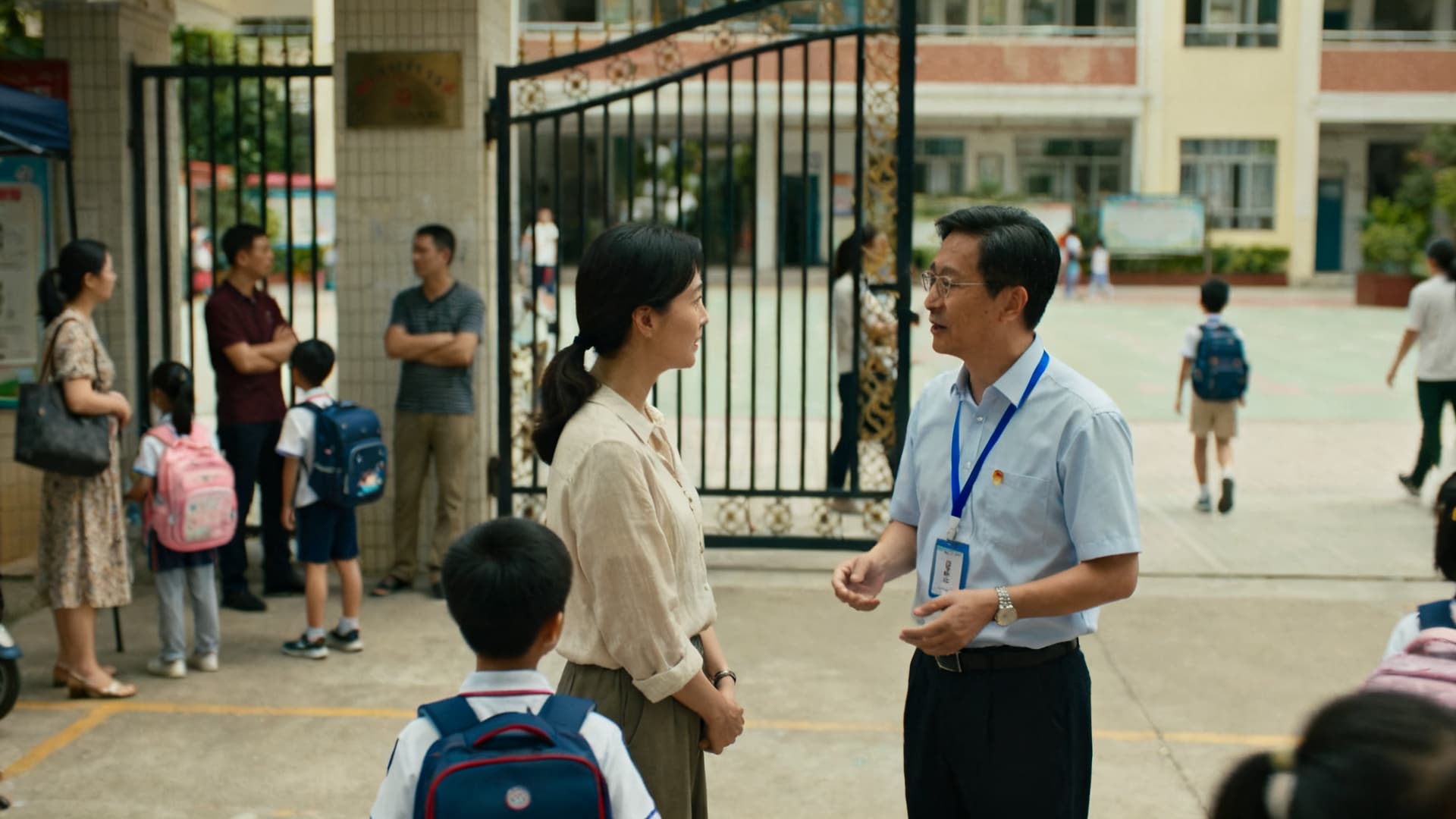 photo: a school yard, parents and an administrator