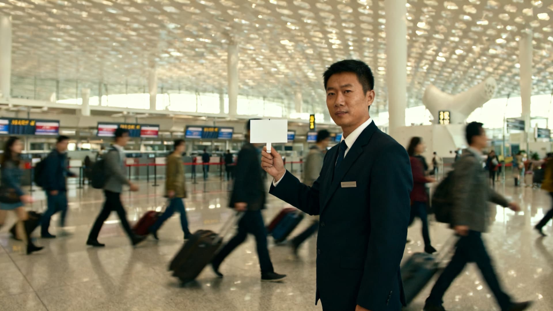 photo: the arrivals hall, a driver with a name sign